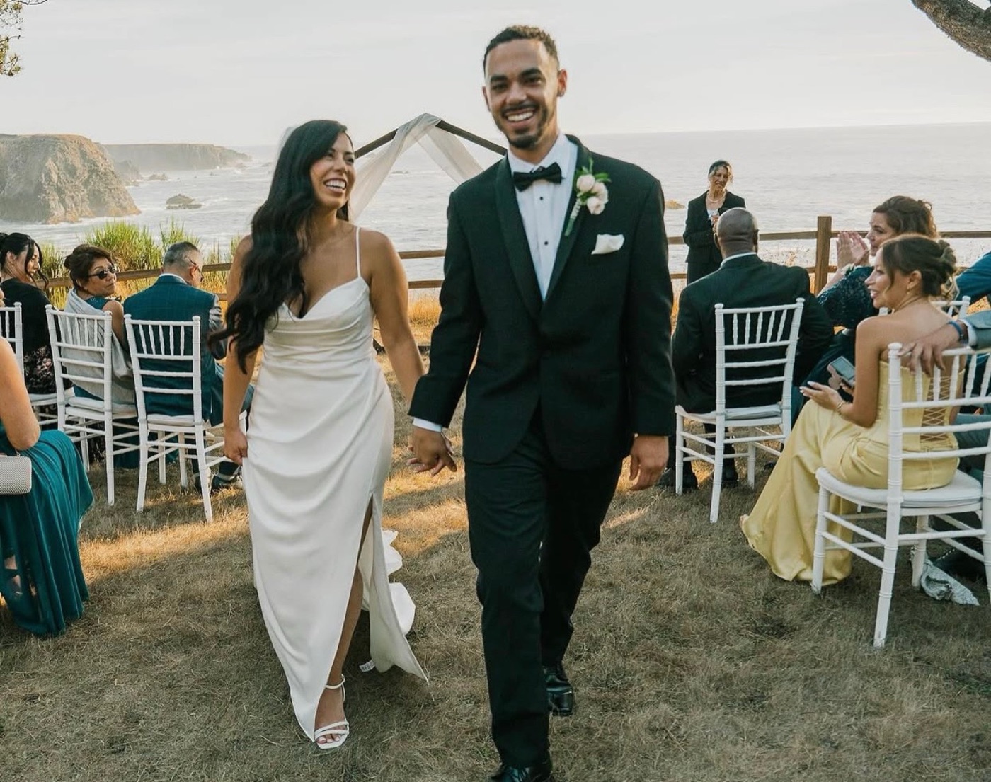 Bride and groom walking down the aisle at a coastal cliff wedding, bridal makeup by Andrea